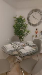 a glass table with chairs and a clock on the wall at Linkwood house in Irvine