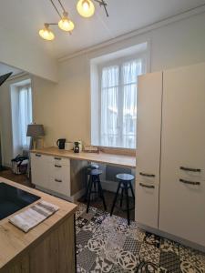 a kitchen with a large white refrigerator and two stools at Ambiance moderne in Roanne +2 photos