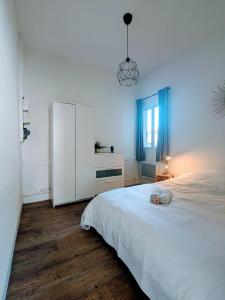 een slaapkamer met een groot wit bed en een raam bij Ambiance moderne in Roanne