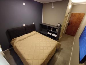 een kleine slaapkamer met een bed en een televisie bij Anchorena 1117 Hotel Suite And Hostel in Buenos Aires