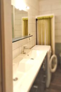La salle de bains est pourvue d'un lavabo blanc et d'un miroir. dans l'établissement Appartement de 2 chambres avec vue sur le lac et jardin clos a Fontrabiouse a 7 km des pistes, à Fontrabiouse