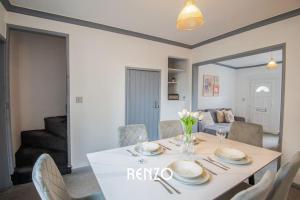 a dining room with a white table and chairs at Bright and Warm Home in Lincoln by Renzo, Free Wi-Fi, Perfect for Staycations! in Lincolnshire