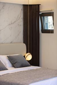Schlafzimmer mit einem Bett mit einer großen Marmorwand in der Unterkunft Naiades Boutique Hotel - Adults Only in Elounda