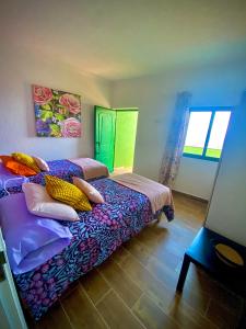 Un dormitorio con una cama con almohadas de colores. en ApKanariooo, en La Frontera