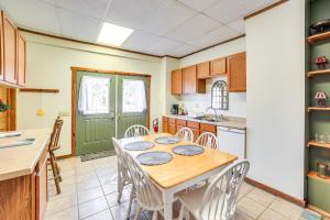 a kitchen with a wooden table and white chairs at Eben Junction Vacation Rental - 2 Mi to Ice Caves! in Chatham