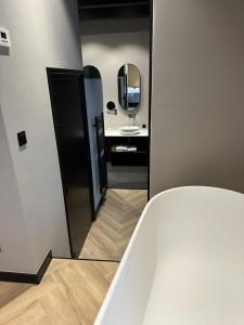 W łazience znajduje się wanna i lustro. w obiekcie Hotel Restaurant Het Witte Paard w mieście Delden