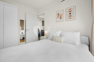 a white bedroom with a white bed and a mirror at Sarwa by Kozystay - Paskal in Bandung +18 photos