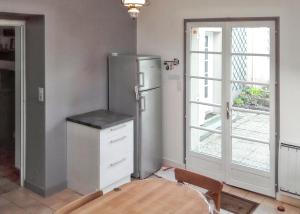 cocina con nevera, mesa y puerta en Maison de 6 chambres avec jardin clos et wifi a Pordic, en Pordic