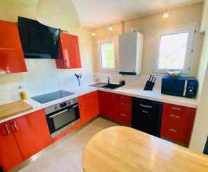 a kitchen with red cabinets and a wooden table at Charmant Duplex en centre-ville in Torcy