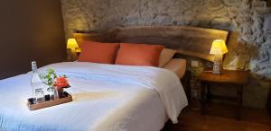 a bedroom with a large white bed with two lamps at B&B La Ferme de Loubens in Loubens-Lauragais