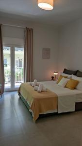 una camera da letto bianca con un grande letto con cuscini di Sage Serenity central appartment a Salonicco