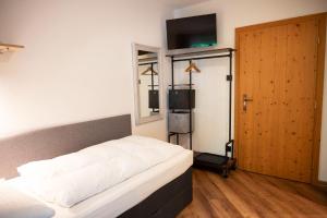 um quarto com uma cama e uma porta com uma televisão em Bed & Breakfast Goldener Stiefel em Mariazell