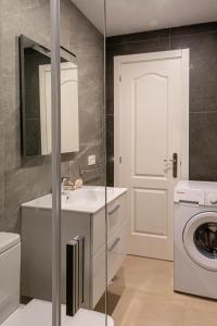 a bathroom with a sink and a washing machine at Kiposhi Beach Apartments Punta Mujeres in Haría +46 photos