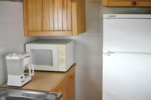 cocina con microondas blanco y fregadero en Chalet de 2 chambres avec jardin amenage a Metabief, en Métabief