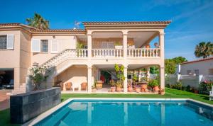 a villa with a swimming pool in front of a house at R153 - Espaciosa Villa con Piscina Privada en Coma in Comarruga