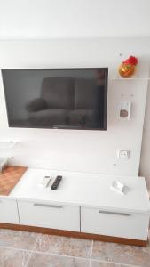 un centro di intrattenimento bianco con TV a schermo piatto a parete di One bedroom apartement at Arinaga 500 m away from the beach with terrace and wifi a Arinaga