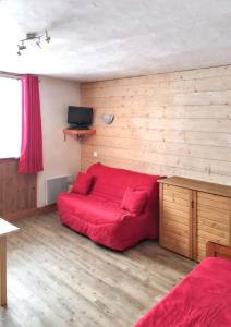 a bedroom with a red bed in a room at Studio a La Plagne Tarentaise a 300 m des pistes avec balcon amenage et wifi in La Plagne Tarentaise
