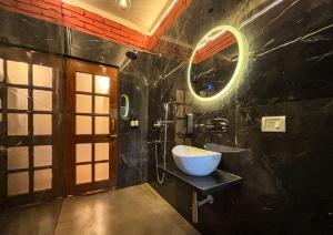 ein Bad mit einem Waschbecken und einem Spiegel in der Unterkunft ITH Luxury Cottage 'Hibiscus' in Varanasi