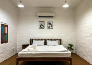 a bedroom with a bed with white walls at ITH Luxury Cottage 'Hibiscus' in Varanasi