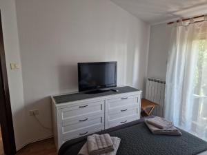 a white dresser with a television on top of it at Sea View Terrace Apartment Izola in Izola