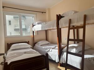 a room with three bunk beds and a window at Apartment Rrihnaj in Shëngjin