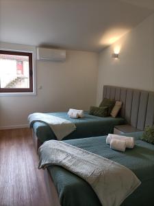 a room with three beds and a couch at AL Fonte de S Tiago in Fafião