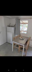 une cuisine avec une table, des chaises et un réfrigérateur dans l'établissement Naphtase - MH487S - Pause Privilège, à Saint-Jean-de-Monts