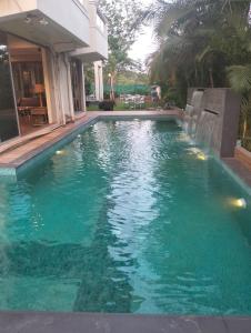 a pool with a waterfall in a house at Villas By Hangout in Lonavala