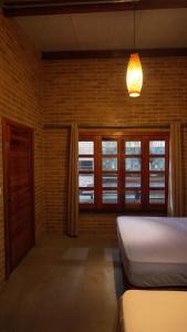 a bedroom with a bed and windows and a lamp at Casa de terra in Alter do Chao