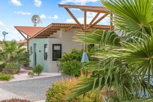 eine Villa mit einem tropischen Garten mit Palmen in der Unterkunft Malvales Resort in Willemstad