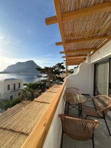 Un balcón con sillas y vistas al océano. en SPONGIA HOTEL AND SUITES, en Myrties