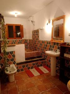 a bathroom with a tub and a toilet and a sink at Cortijo Rural Al-Andalus con Piscina in Órgiva