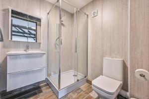 a bathroom with a shower and a toilet and a sink at Goonwinnow Farm Cottages in Newquay