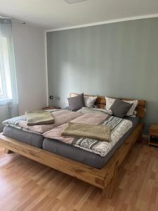 1 cama grande de madera con almohadas en la habitación en Ferienwohnungen Hoheeifel zentral in Kelberg, Nähe Nürburgring, en Kelberg