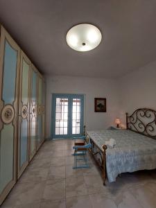 a bedroom with a bed and a chair in it at La Maison de Lucietta in Lucera