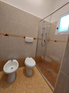 a bathroom with a toilet and a glass shower at La Maison de Lucietta in Lucera +8 photos
