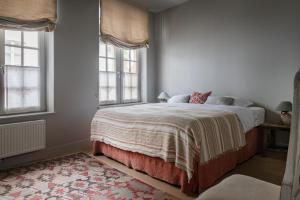 a bedroom with a bed and two windows at Guesthouse Aubrey - Charming Cottage in the Heart of Bruges in Bruges