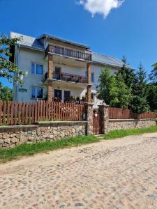 a house with a fence in front of it at Agroturystyka Krzywy Zakątek in Krzywe