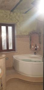 a large white tub in a bathroom with a window at Casa fiabesca a Sperlonga in Sperlonga +21 photos
