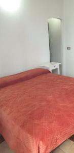 a bed with a red comforter in a room at Casa fiabesca a Sperlonga in Sperlonga