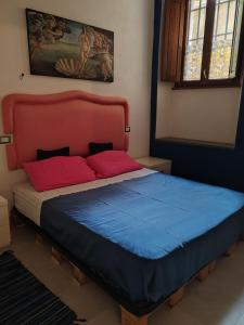 uma cama com lençóis vermelhos e azuis num quarto em L'antico borgo em Buti