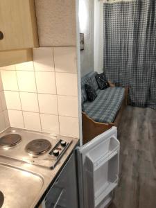 a small kitchen with a stove and a bed at Studio avec balcon a Modane in Modane