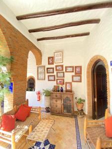 uma sala de estar cheia de mobiliário e uma parede de tijolos em Riad Gharnata em Chefchaouen