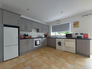 a kitchen with white cabinets and a tile floor at 3 bed semi-detached house in a quite estate in Bruff