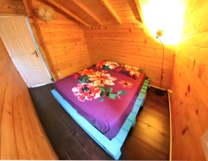 ein Bett in einem Holzzimmer mit Blumen darauf in der Unterkunft Chalet de 3 chambres avec piscine partagee jacuzzi et jardin amenage a Vincendo Saint Joseph in Saint-Joseph