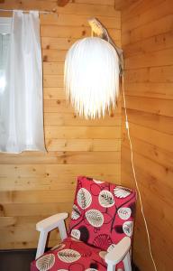 Zimmer mit einem roten Stuhl und einer Lampe in der Unterkunft Chalet de 3 chambres avec piscine partagee jacuzzi et jardin amenage a Vincendo Saint Joseph in Saint-Joseph