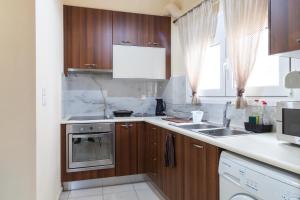 a kitchen with wooden cabinets and a sink at Windmill 23 Apartment in Agios Nikolaos