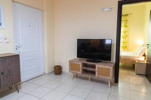 a living room with a flat screen tv on a cabinet at Windmill 23 Apartment in Agios Nikolaos