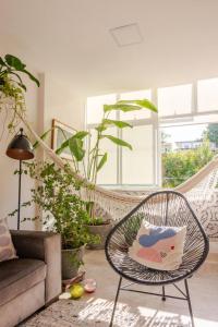 a rattan chair in a living room with plants at Casa da Cacá in Salvador