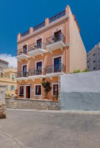 un edificio rosa con balcones en una calle en Electra Syros - Adults Only, en Ermoupoli